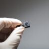 a hand holding a black and small hidden camera