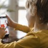 side view boy using smartphone home