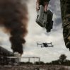 uav operator with remote control stands against background destroyed building with black smoke city concept unmanned technologies modern warfare bombing reconnaissance drone