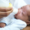 baby with cleft lip milk mom feeding from bottle nutrition health wellness formula newborn hand mother feed child development growth healthy diet food lunch home