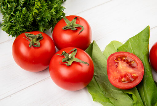 close up view vegetables as coriander tomato spinach wooden table
