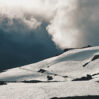heavy clouds hang mountains covered with snow