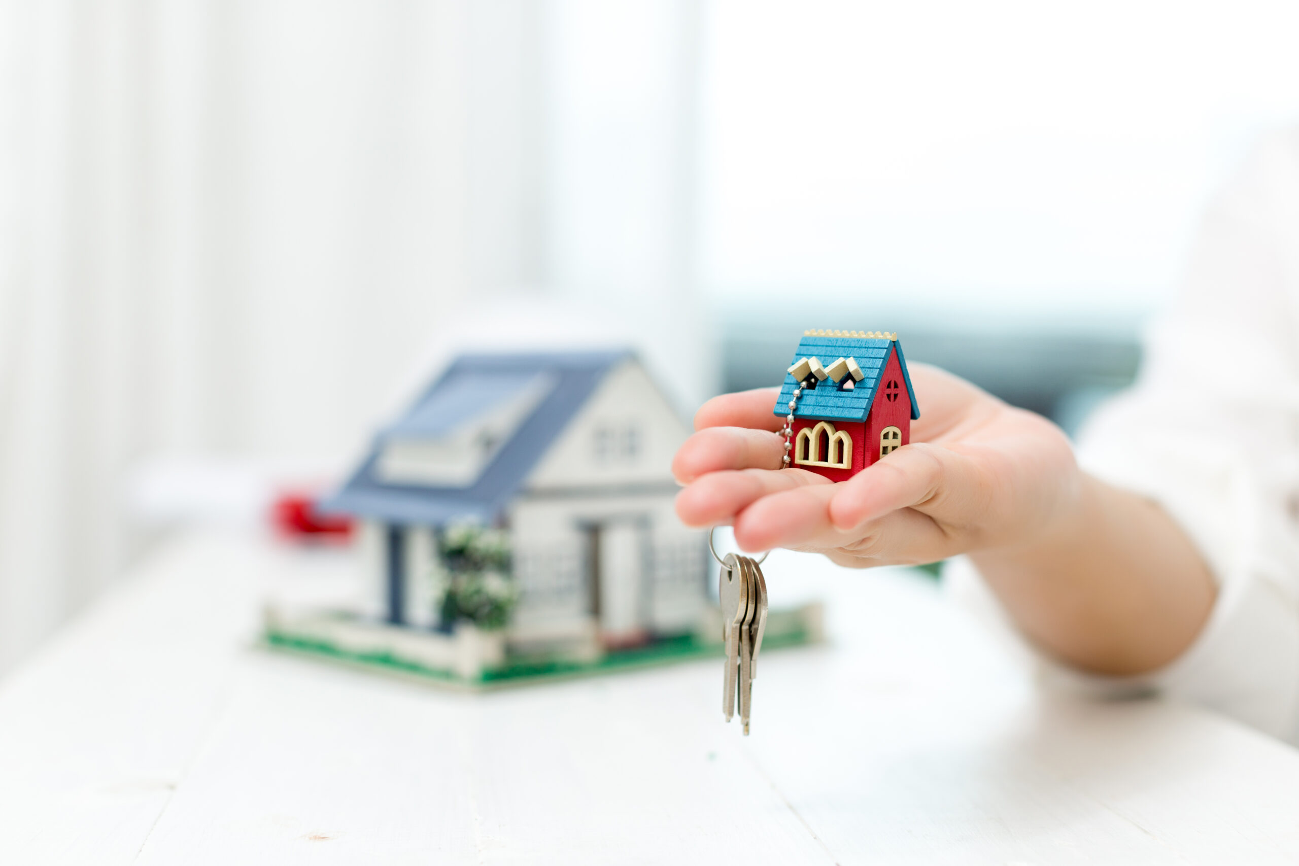 real estate agent with house model keys scaled