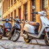 three scooters are parked cobblestone street