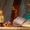 An open Quran rests next to a bowl of dates and a decorated lantern GettyImages 1368465583